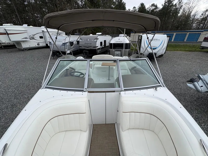 Slide: The Image of 2007 Cobalt 232 Bowrider boat with white seating, parked among RVs and trailers. - 22