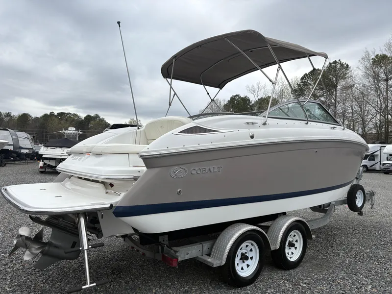 Slide: The Image of 2007 Cobalt 232 Bowrider boat on trailer, parked outdoors under cloudy sky. - 4