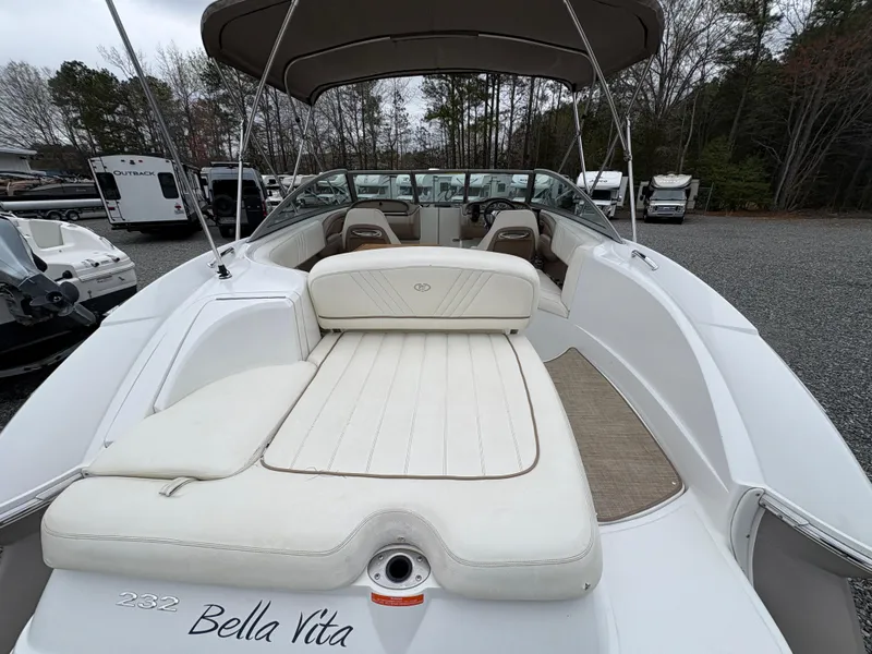 Slide: The Image of 2007 Cobalt 232 Bowrider boat with white seating and canopy, parked outdoors. - 8