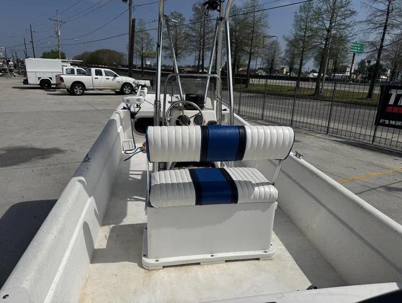 Slide: The Image of 2010 Carolina Skiff DLV 178 boat with white and blue seating, parked outdoors. - 14