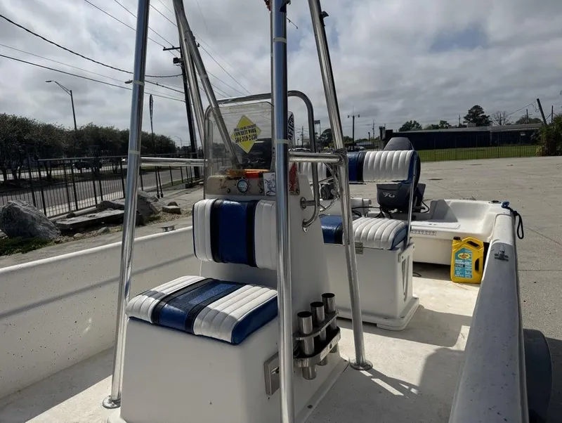 Slide: The Image of 2010 Carolina Skiff DLV 178 boat interior with blue and white seating, docked outdoors. - 9