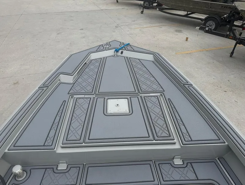 Slide: The Image of 2023 Rene Gros Custom 20 boat deck with geometric patterns, parked on concrete surface. - 8