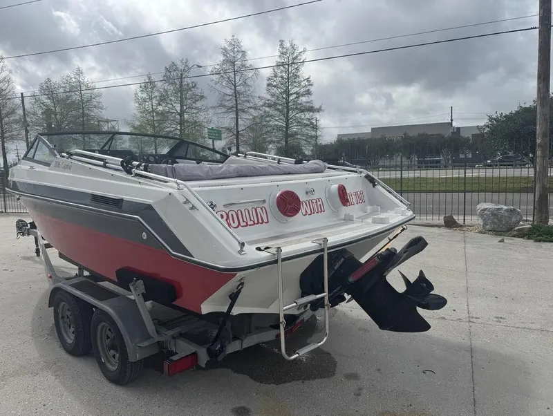 Slide: The Image of 1990 Rinker 206 Captiva Cuddy boat on trailer, parked outdoors under cloudy sky. - 6