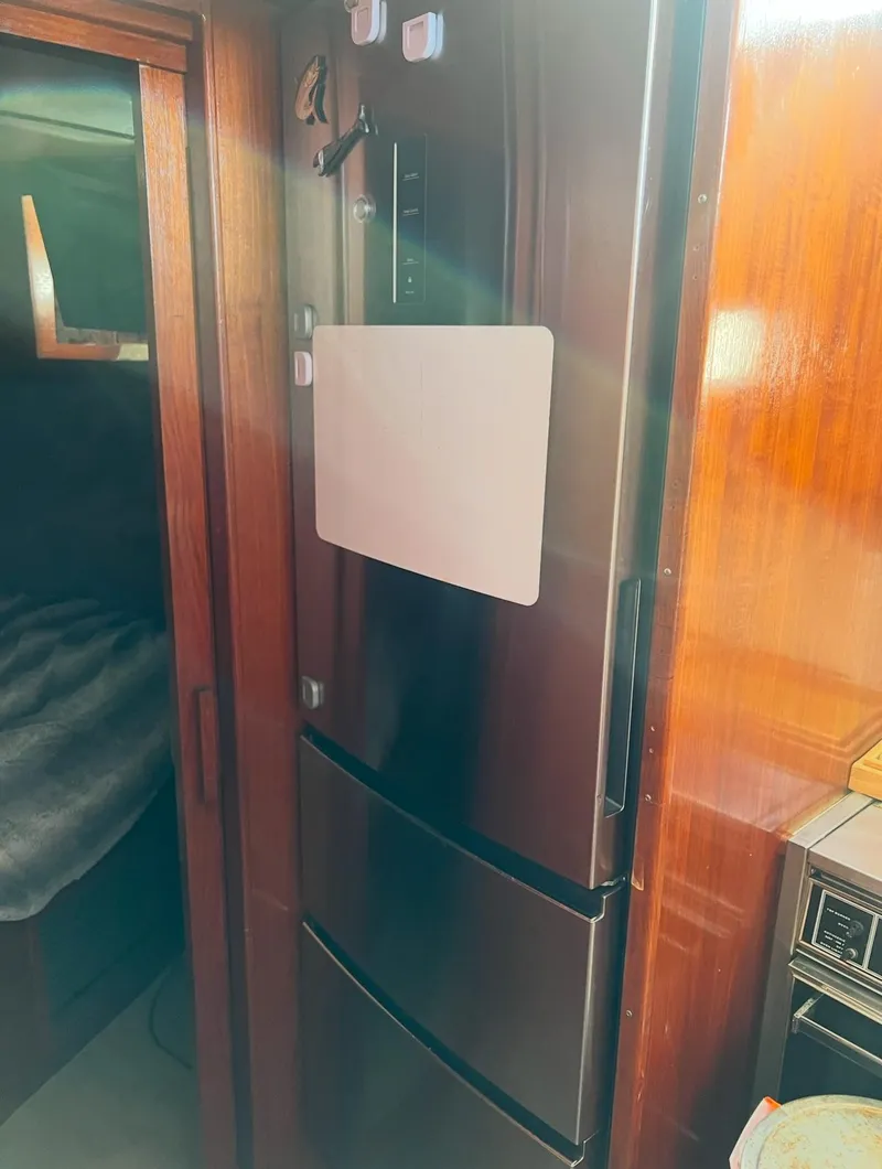 Slide: The Image of 1988 Jersey 40FT Convertible interior with modern refrigerator and wooden cabinetry. - 11