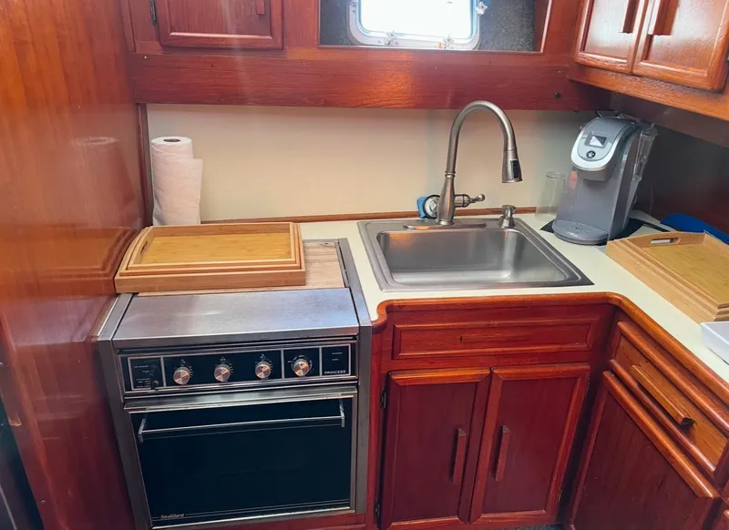 Slide: The Image of 1988 Jersey 40FT Convertible yacht kitchen with sink, stove, and wooden cabinetry. - 12