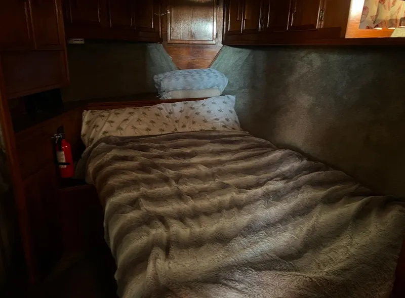 Slide: The Image of Cozy bedroom in 1988 Jersey 40FT Convertible boat with wooden cabinets and plush bedding. - 15