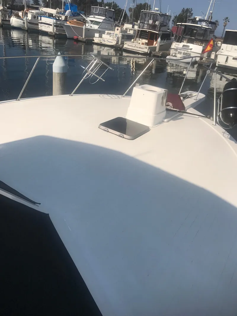 Slide: The Image of 1988 Jersey 40FT Convertible boat docked in a marina, surrounded by other vessels. - 18