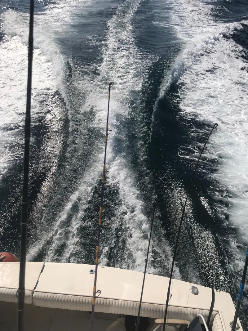 Slide: The Image of 1988 Jersey 40FT Convertible boat with fishing rods, creating a wake in the ocean. - 19