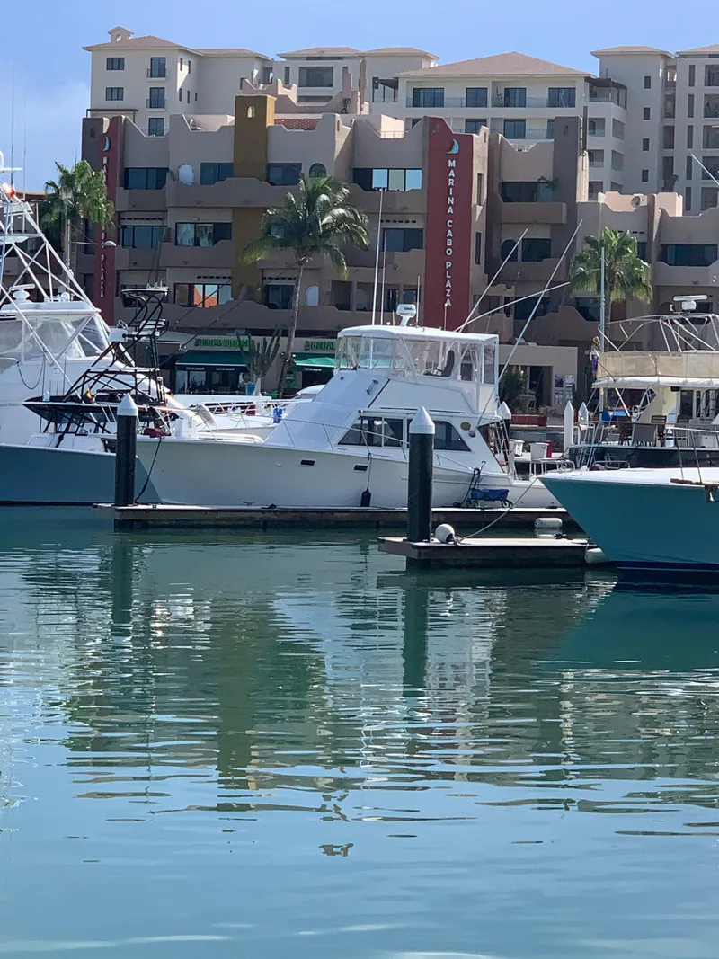 Slide: The Image of 1988 Jersey 40FT Convertible yacht docked in a marina with modern buildings in the background. - 2