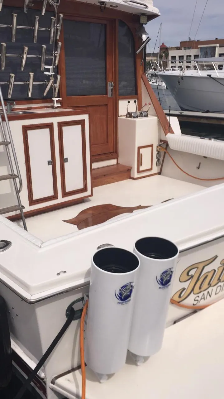 Slide: The Image of 1988 Jersey 40FT Convertible boat docked, featuring a wooden cabin and fishing rod holders. - 20