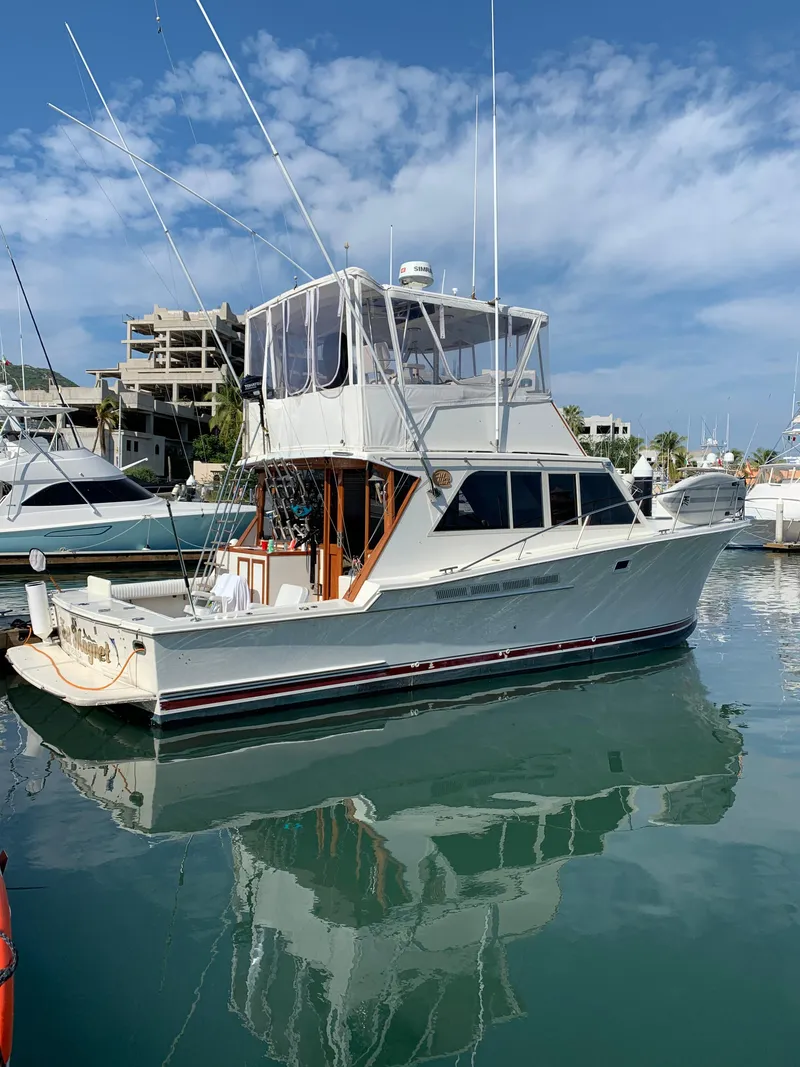 Slide: The Image of 1988 Jersey 40FT Convertible boat docked in a marina under a clear blue sky. - 3