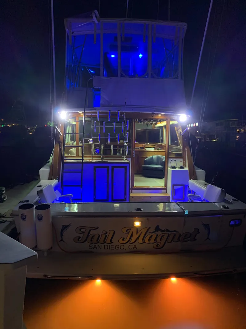 Slide: The Image of 1988 Jersey 40FT Convertible boat with blue lights, docked at night in San Diego. - 6