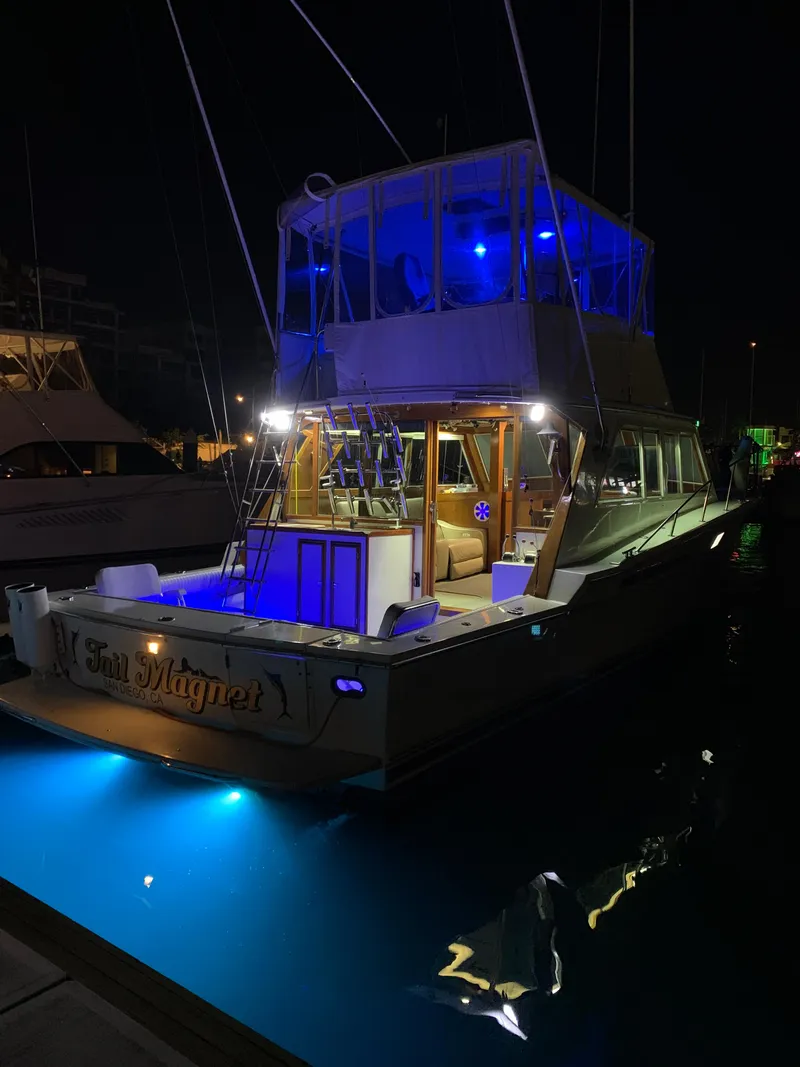 Slide: The Image of 1988 Jersey 40FT Convertible yacht illuminated with blue lights at night. - 7