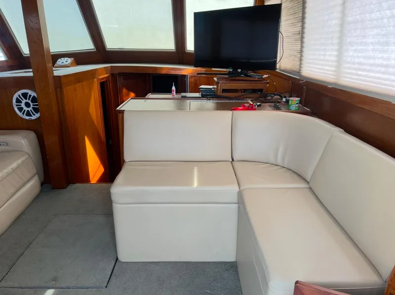Slide: The Image of Interior of a 1988 Jersey 40FT Convertible yacht with beige seating and a TV. - 8