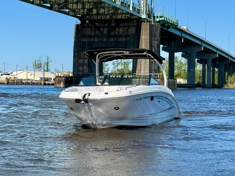 Slide: The Image of 2017 Sea Ray SDX 270 Outboard boat cruising under a bridge on a sunny day. - 2