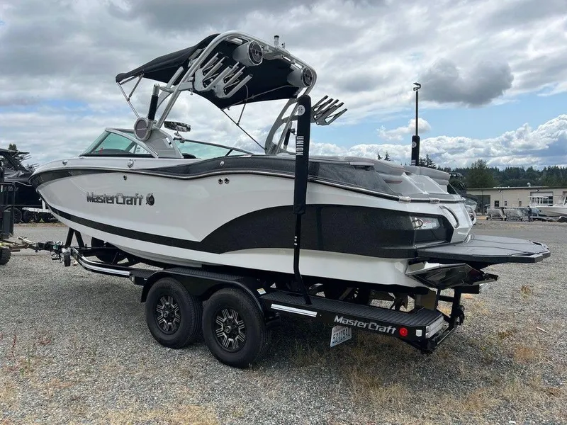 Slide: The Image of 2019 MasterCraft X22 boat on trailer, parked outdoors under cloudy sky. - 3