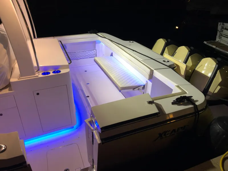 Slide: The Image of 2019 Altima 38 Xcape boat with illuminated deck and seating area at night. - 11