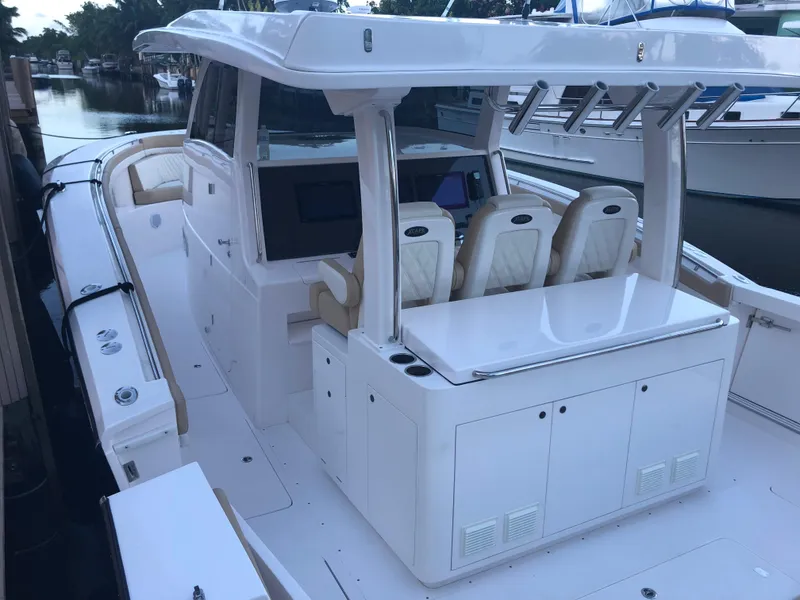 Slide: The Image of 2019 Altima 38 Xcape boat with sleek design and spacious seating at a marina. - 12