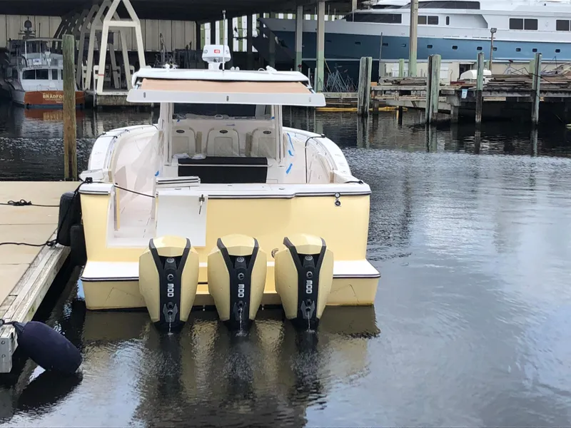 Slide: The Image of 2019 Altima 38 Xcape boat docked with triple outboard engines. - 8