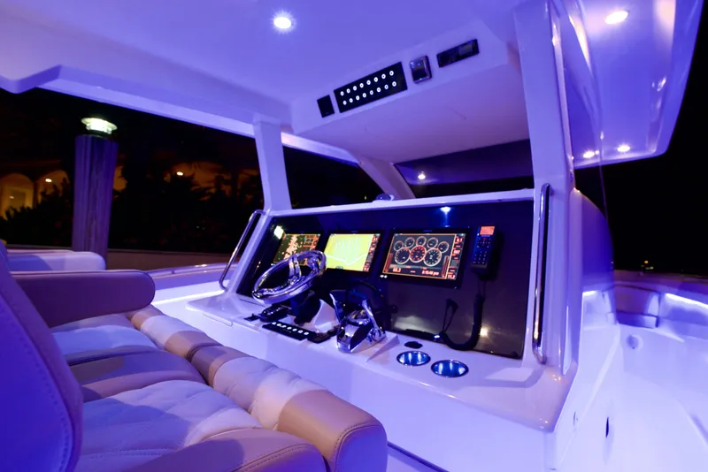 Slide: The Image of Luxurious 2019 Altima 38 Xcape boat cockpit with illuminated controls and plush seating. - 9