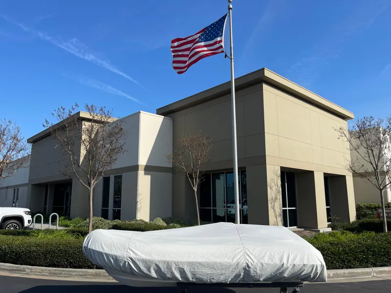 Slide: The Image of Covered 2011 Williams Jet Tenders 325 Turbo Jet in front of modern building with American flag. - 15