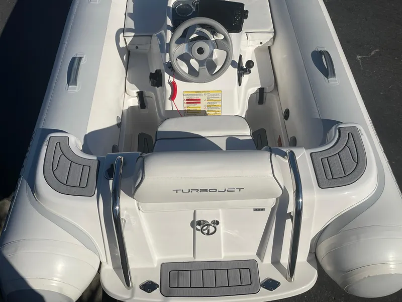 Slide: The Image of 2011 Williams Jet Tenders 325 Turbo Jet, white inflatable boat, top view of cockpit and steering. - 4