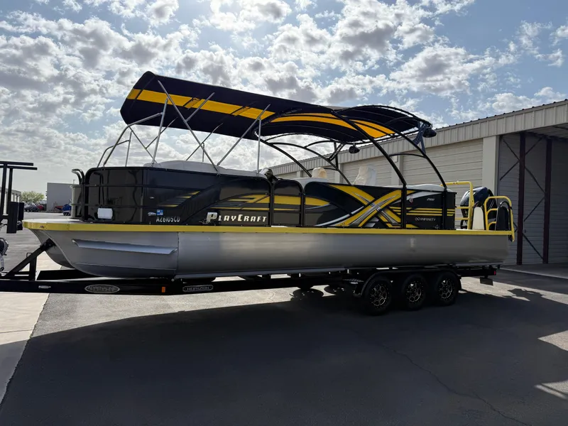 Slide: The Image of 2021 PlayCraft Infinity 2900 pontoon boat with vibrant yellow and black design on a trailer. - 14