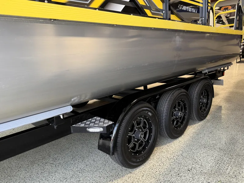 Slide: The Image of 2021 PlayCraft Infinity 2900 boat on a triple-axle trailer in a showroom. - 18