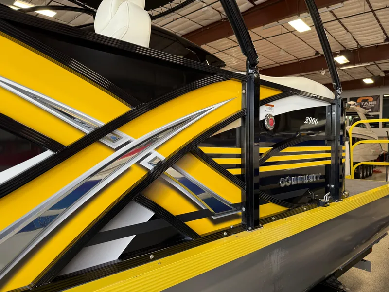 Slide: The Image of 2021 PlayCraft Infinity 2900 boat with vibrant yellow and black design in a showroom. - 20