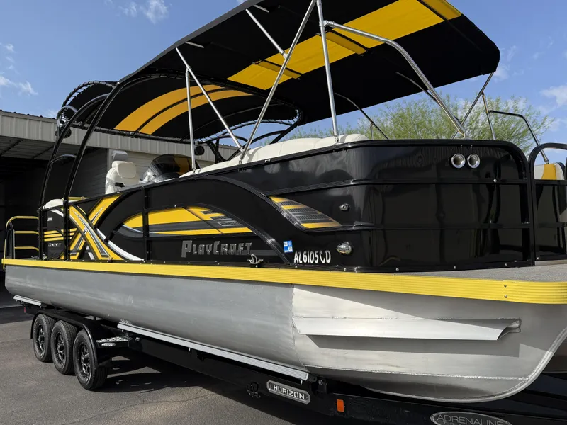 Slide: The Image of 2021 PlayCraft Infinity 2900 pontoon boat with black and yellow design on a trailer. - 3