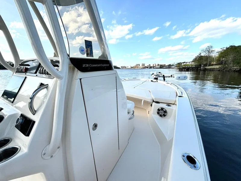 Slide: The Image of 2024 Grady-White 231 Coastal Explorer boat on calm water, showcasing sleek design and spacious deck. - 10