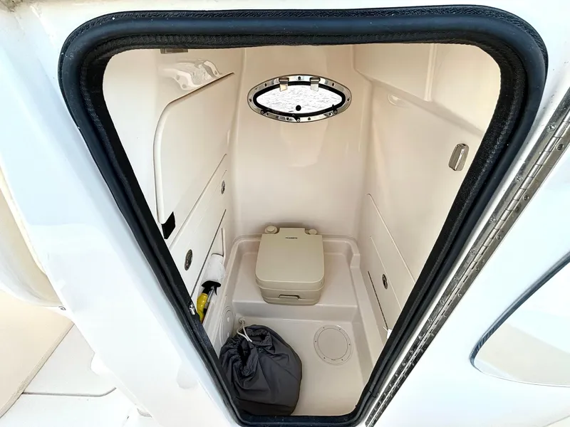 Slide: The Image of 2024 Grady-White 231 Coastal Explorer boat interior with compact marine toilet. - 15