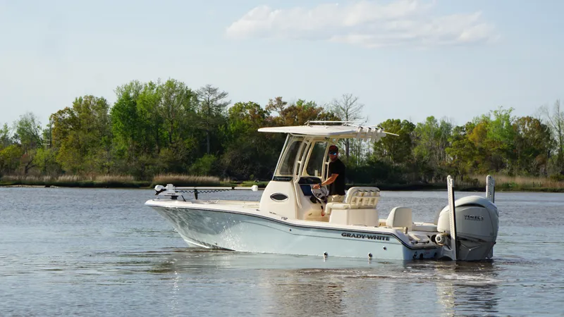 Slide: The Image of 2024 Grady-White 231 Coastal Explorer boat cruising on a serene lake. - 4