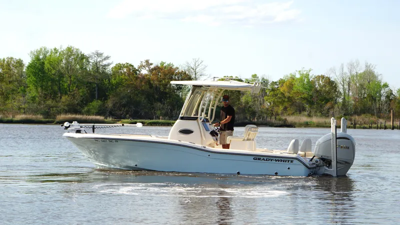 Slide: The Image of 2024 Grady-White 231 Coastal Explorer boat cruising on a calm river. - 6
