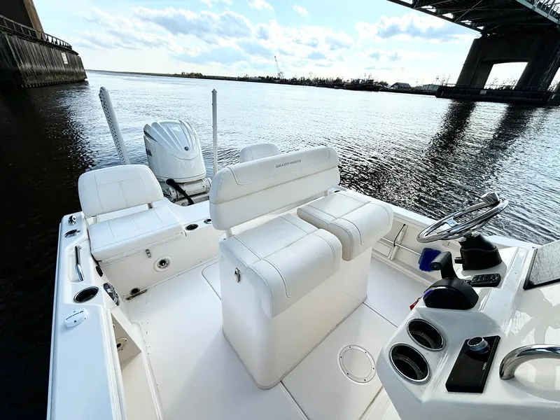 Slide: The Image of 2024 Grady-White 231 Coastal Explorer boat interior on calm water under a bridge. - 9