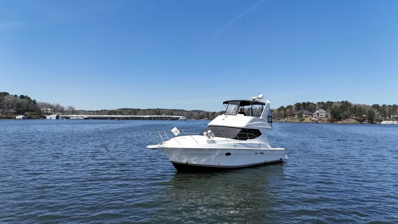 Slide: The Image of 2007 Silverton 36 Convertible yacht on a serene lake under clear blue skies. - 11