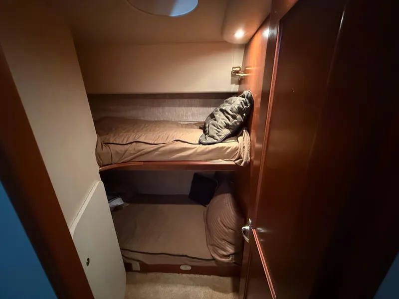 Slide: The Image of 2007 Silverton 36 Convertible cabin with cozy bunk beds and warm lighting. - 30