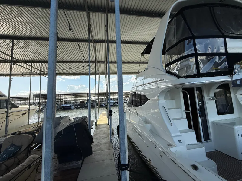 Slide: The Image of 2007 Silverton 36 Convertible yacht docked in a marina under a covered shelter. - 31