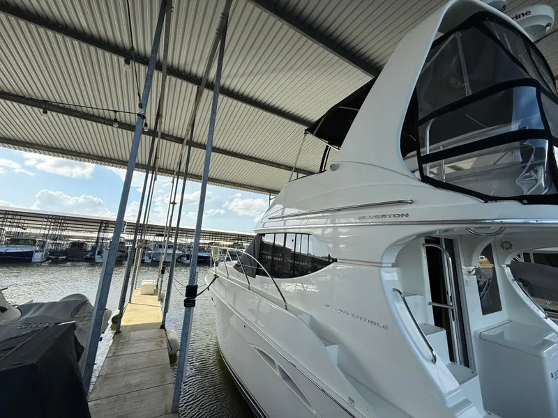 Slide: The Image of 2007 Silverton 36 Convertible yacht docked under a marina canopy. - 32