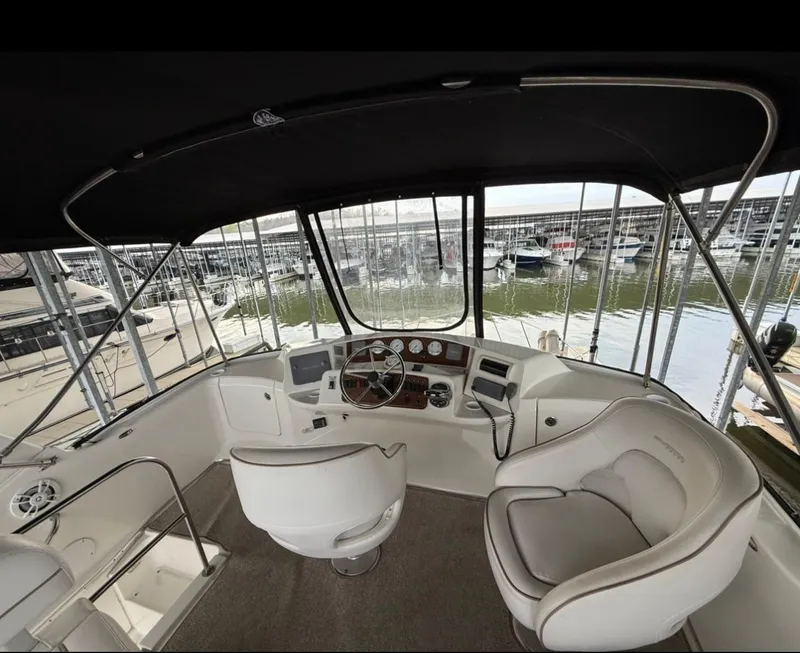 Slide: The Image of 2007 Silverton 36 Convertible yacht helm with marina view, featuring modern controls and seating. - 33