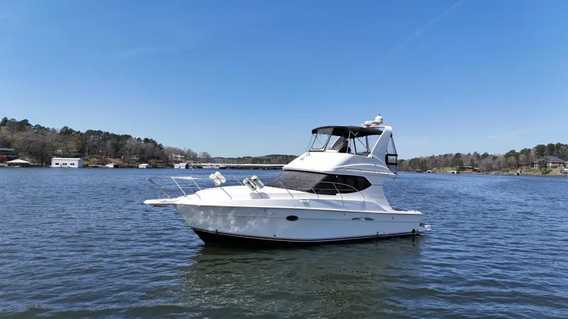 Slide: The Image of 2007 Silverton 36 Convertible yacht on a serene lake under a clear blue sky. - 9