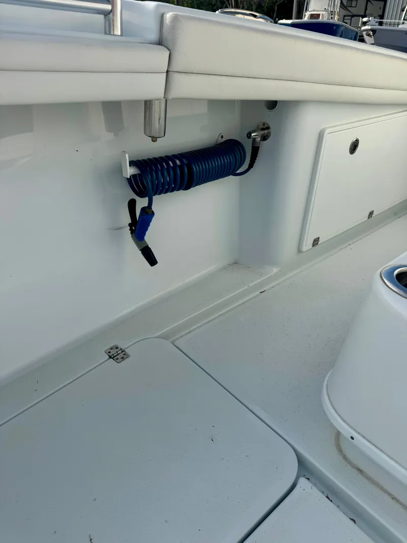 Slide: The Image of 2022 Yellowfin 36 Open boat interior with coiled blue hose and storage compartments. - 17