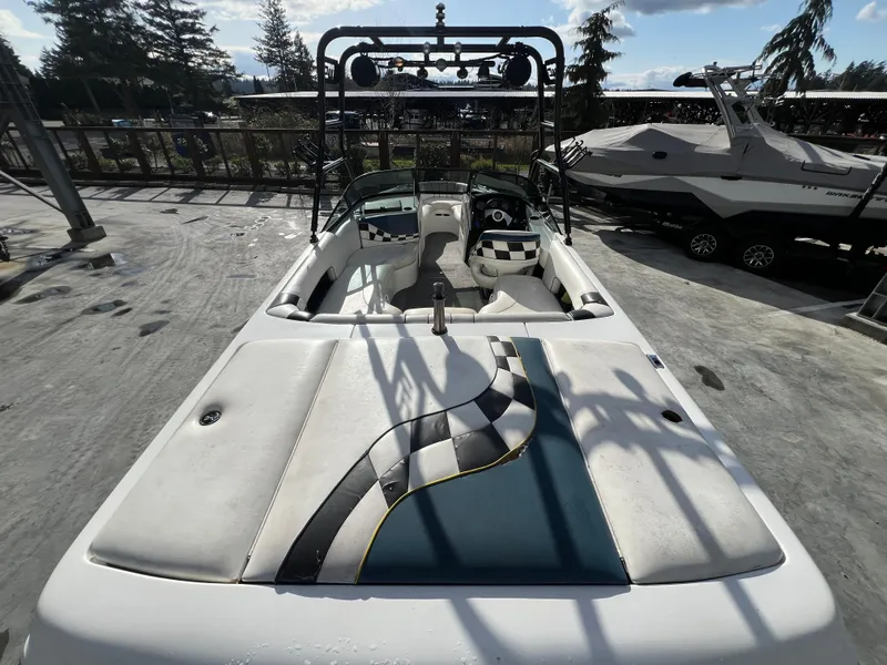 Slide: The Image of 2002 MB B52 boat with checkered interior, parked outdoors under a sunny sky. - 10