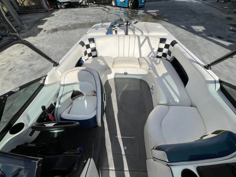 Slide: The Image of Interior of a 2002 MB B52 boat with white seating and checkered accents. - 19