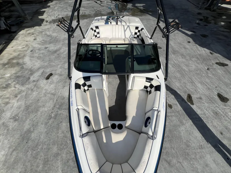 Slide: The Image of 2002 MB B52 boat with checkered seats, viewed from above on concrete surface. - 21