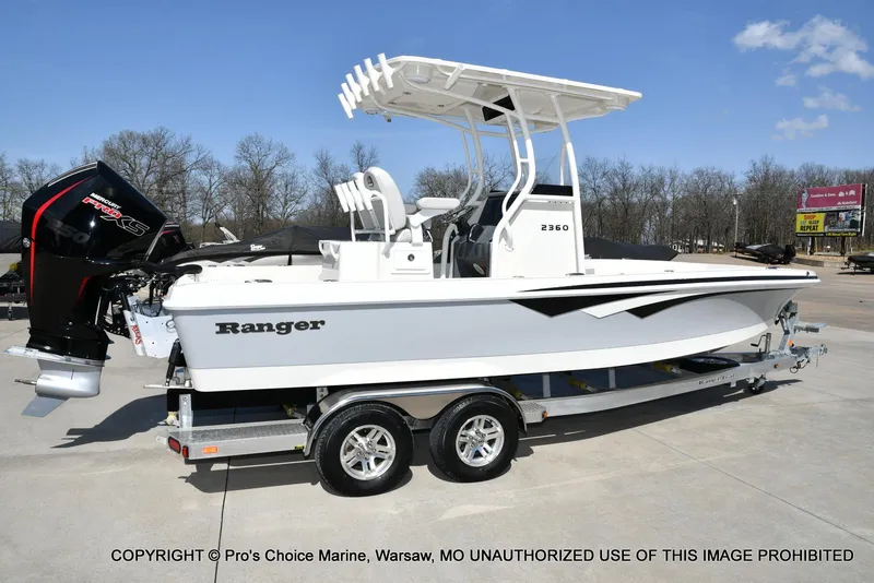 Slide: The Image of 2023 Ranger 2360 Bay boat on trailer, featuring a powerful outboard motor. - 13