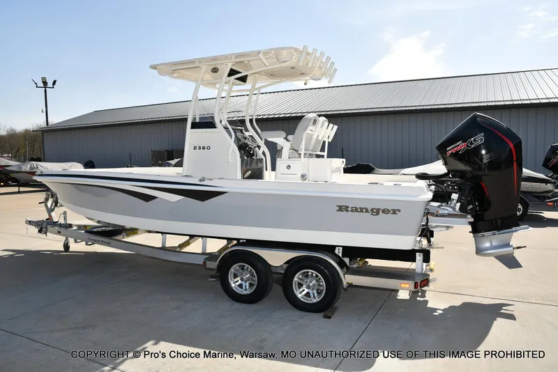 Slide: The Image of 2023 Ranger 2360 Bay boat on trailer, featuring powerful outboard motor. - 18