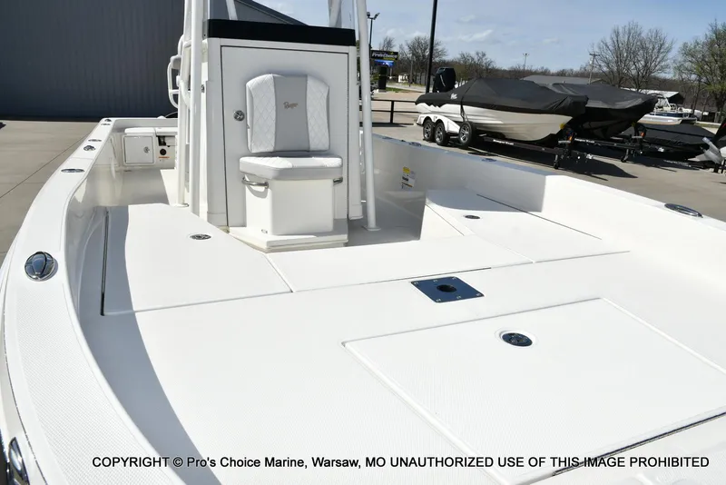 Slide: The Image of 2023 Ranger 2360 Bay boat with spacious deck and seating, displayed outdoors. - 22