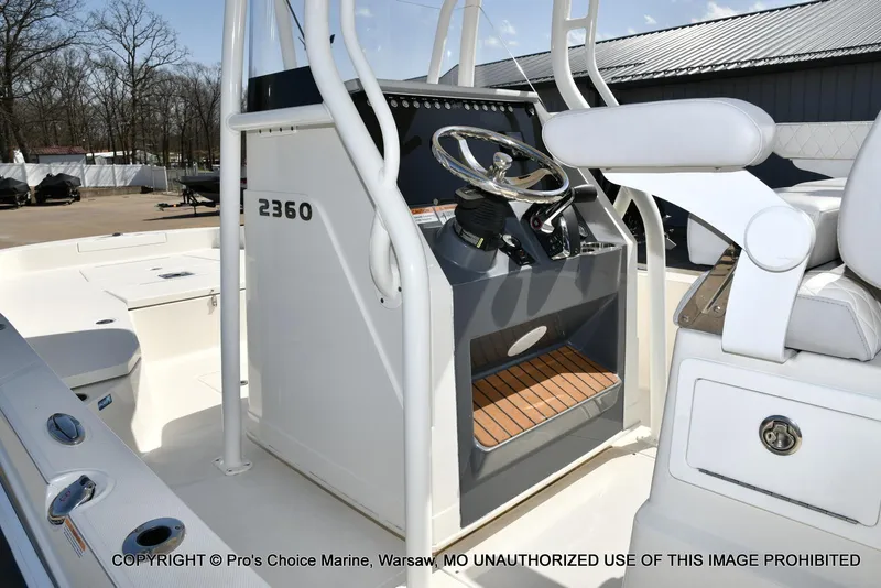 Slide: The Image of 2023 Ranger 2360 Bay boat interior with steering console and seating, displayed outdoors. - 28