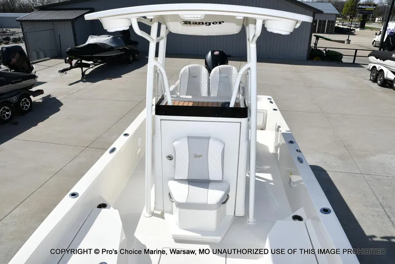 Slide: The Image of 2023 Ranger 2360 Bay boat with white seating and console, parked outdoors. - 3